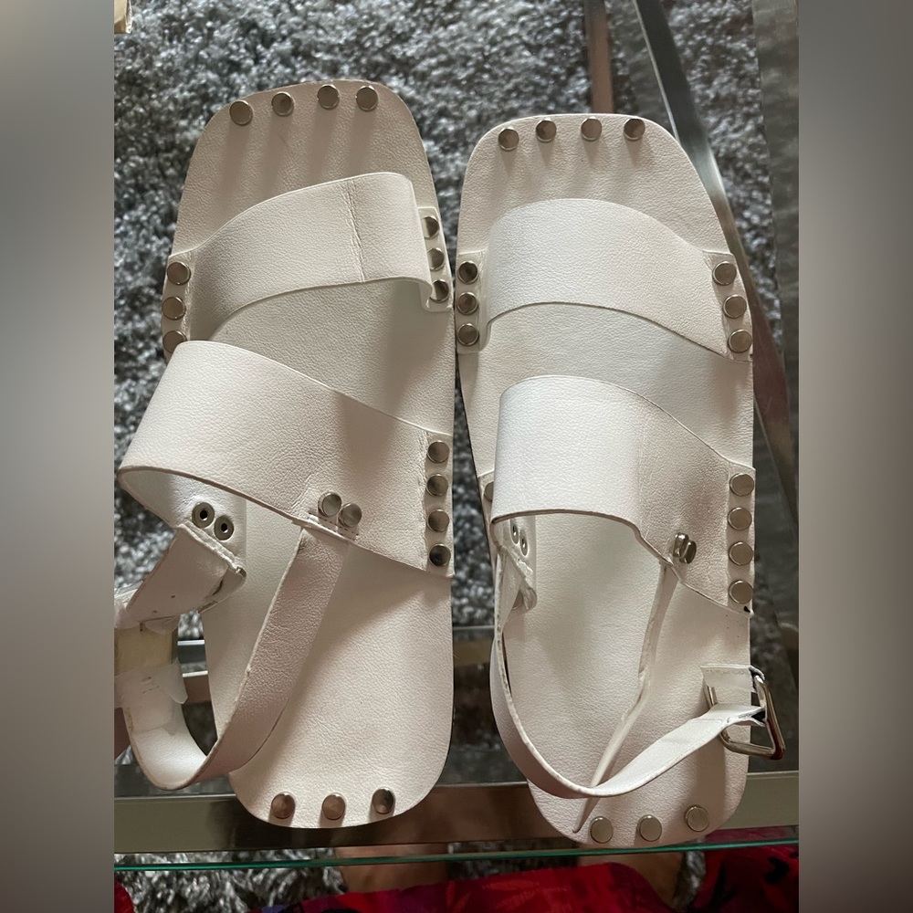 handcrafted fashion-forward white leather sandal with silver tone stud detail..